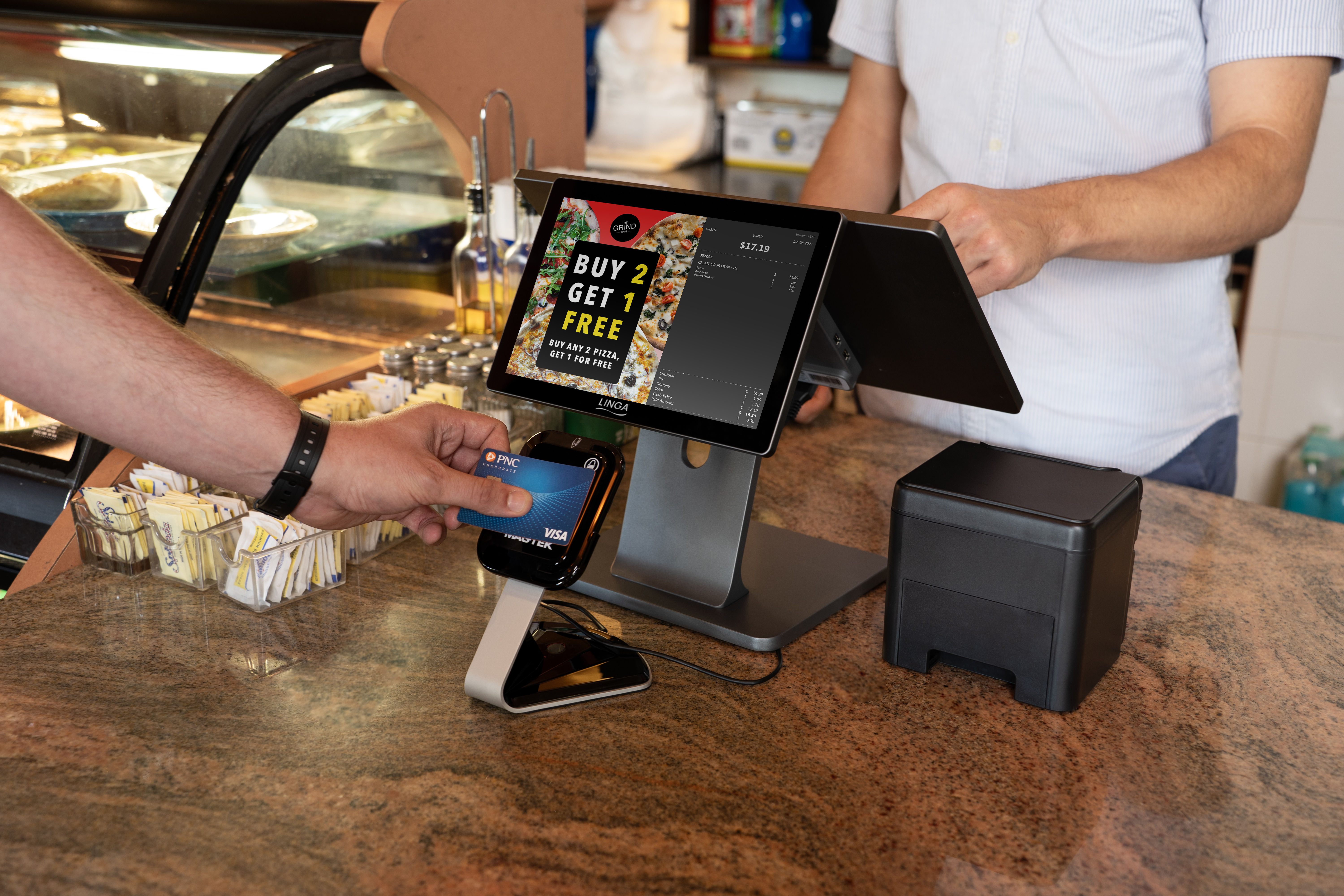 A person paying with their PNC credit card at a quick-service restaurant.