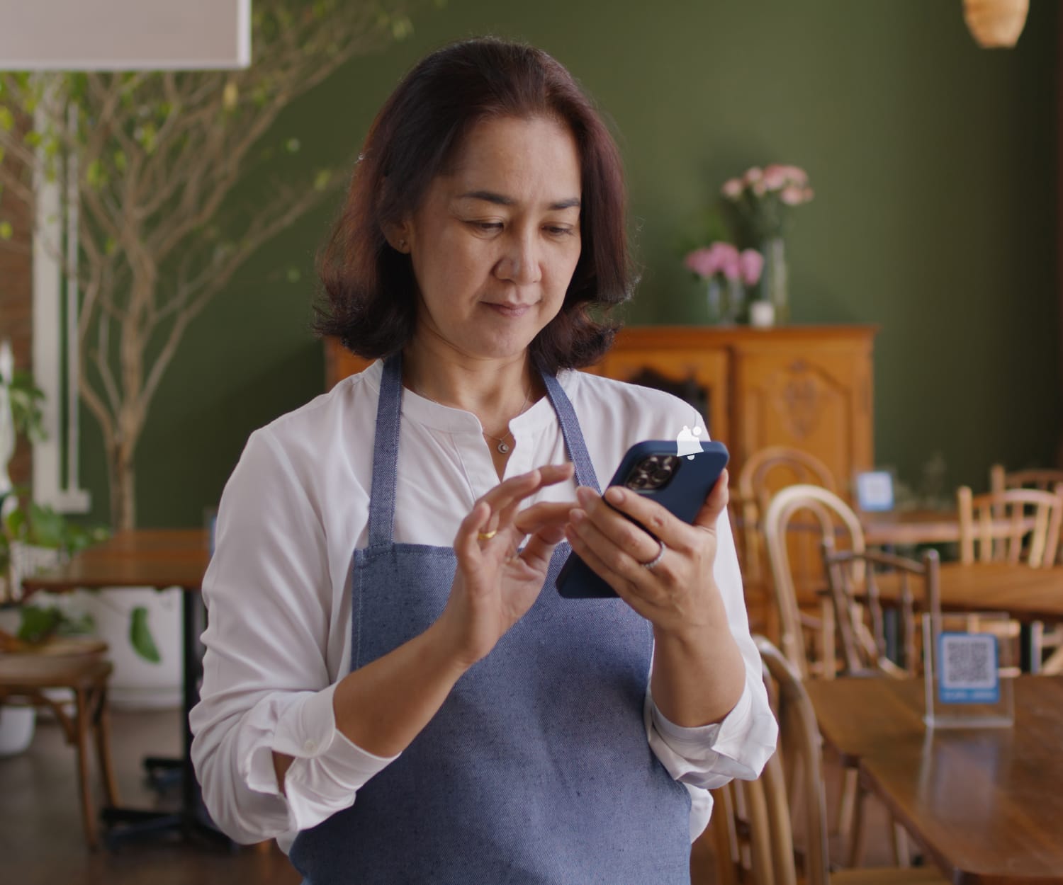 A restaurant employee using a smart phone.