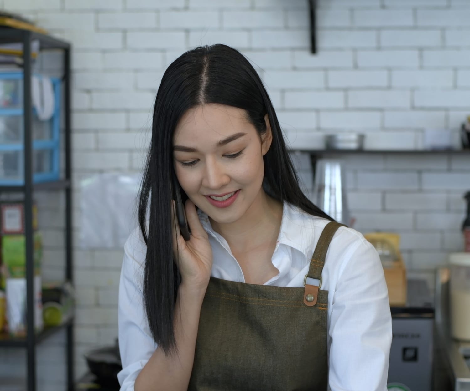 A restaurant employee using a cell phone to take orders.